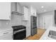 Kitchen boasts stainless steel appliances, white cabinets, quartz countertops and backsplash, and a view of the staircase at 4054 Boulevard Pl, Indianapolis, IN 46208