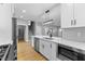 Open-concept kitchen with stainless steel appliances, white cabinets, quartz countertops, an island, and hardwood flooring at 4054 Boulevard Pl, Indianapolis, IN 46208
