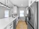 Modern kitchen features stainless steel appliances, white cabinets, and quartz countertops with a view from the kitchen window at 4054 Boulevard Pl, Indianapolis, IN 46208