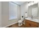 Well-lit half bathroom with wood-look floors and a vanity with a marble countertop at 4063 S Meadow Wood Ct, New Palestine, IN 46163