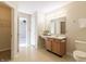 Bathroom vanity featuring a framed mirror, warm lighting, neutral countertops, and wooden cabinetry at 4063 S Meadow Wood Ct, New Palestine, IN 46163