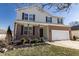 Traditional two-story home with brick accents, manicured landscaping, and a covered front porch at 4063 S Meadow Wood Ct, New Palestine, IN 46163