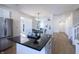 Open kitchen with island, stainless steel refrigerator, and hardwood floors flowing into the dining area at 4063 S Meadow Wood Ct, New Palestine, IN 46163