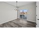 Bright dining room featuring hardwood floors, a modern chandelier, and a sliding glass door to the balcony for outdoor dining at 4180 Douro Trl, Westfield, IN 46062