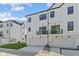 Rear exterior of a modern townhome featuring garages, a balcony, and clean white siding at 4180 Douro Trl, Westfield, IN 46062