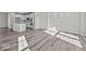 Open concept with wood-look flooring, white kitchen island, and stainless steel appliances at 4180 Douro Trl, Westfield, IN 46062