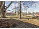 Large fenced backyard featuring mature trees and an expansive lawn, perfect for outdoor activities at 4808 N Tuxedo St, Indianapolis, IN 46205