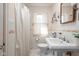 Classic bathroom featuring a pedestal sink, tiled walls, and a bright window with neutral tones at 4808 N Tuxedo St, Indianapolis, IN 46205