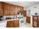 Classic kitchen featuring wood cabinets and white appliances, providing a functional cooking space at 4808 N Tuxedo St, Indianapolis, IN 46205