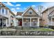 Charming craftsman home featuring a red door, covered porch, and well-maintained landscaping at 523 Terrace Ave, Indianapolis, IN 46203
