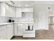 Updated kitchen with white cabinets and appliances, including a range oven with towels at 523 Terrace Ave, Indianapolis, IN 46203