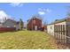 Expansive backyard enclosed by a red picket fence with a cozy patio space for outdoor relaxation at 5334 E Burgess Ave, Indianapolis, IN 46219
