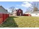 Spacious backyard featuring a well-maintained lawn and red picket fence, perfect for outdoor activities at 5334 E Burgess Ave, Indianapolis, IN 46219