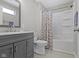 Modern bathroom with gray vanity, updated fixtures, and a shower-tub combination, offering a sleek design at 5334 E Burgess Ave, Indianapolis, IN 46219