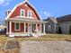 Charming two-story home with red siding, white trim, and a cozy covered front porch at 5334 E Burgess Ave, Indianapolis, IN 46219