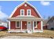 Charming two-story home with red siding, white trim, and a cozy covered front porch at 5334 E Burgess Ave, Indianapolis, IN 46219