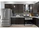 Updated kitchen featuring stainless steel appliances, dark cabinetry and gray backsplash at 5334 E Burgess Ave, Indianapolis, IN 46219
