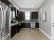Modern kitchen with stainless steel appliances, dark cabinets, and gray backsplash at 5334 E Burgess Ave, Indianapolis, IN 46219
