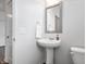 Modern half bath featuring a pedestal sink, toilet, framed mirror, and neutral wall paint at 5646 Mahogany Dr, Noblesville, IN 46062