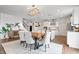 Open-concept dining room with wood table, upholstered chairs, stylish rug, and adjacent kitchen area at 5646 Mahogany Dr, Noblesville, IN 46062