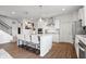 Bright kitchen with white cabinets, stainless steel appliances, an island with seating, and hardwood floors at 5646 Mahogany Dr, Noblesville, IN 46062