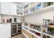 Organized pantry with shelves, storage containers, a wine fridge, and ample storage space at 5646 Mahogany Dr, Noblesville, IN 46062