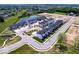 Aerial view of a new construction community featuring modern townhomes and a central pond at 7062 Nine Penny Dr, Brownsburg, IN 46112