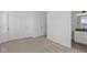 This bedroom features neutral carpet, white walls, closet space, and an ensuite bathroom at 7062 Nine Penny Dr, Brownsburg, IN 46112
