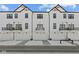 Modern townhomes featuring white exteriors, black trim, garage doors, and small balconies at 7062 Nine Penny Dr, Brownsburg, IN 46112