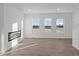 Living room with wood-look floors, a modern fireplace and lots of natural light at 7062 Nine Penny Dr, Brownsburg, IN 46112