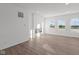 Bright living room featuring wood-look floors, fireplace, and large windows at 7062 Nine Penny Dr, Brownsburg, IN 46112