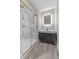 Modern bathroom featuring marble tile shower with glass door and sleek vanity with lighted mirror at 714 S Keystone Ave, Indianapolis, IN 46203