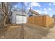 A detached garage with a white door and a driveway needing repair at 714 S Keystone Ave, Indianapolis, IN 46203