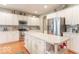 Modern kitchen featuring stainless steel appliances, white cabinetry, and a spacious center island with hardwood floors at 7823 Beechwood Farms Dr, Avon, IN 46123
