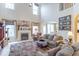 Cozy living room featuring a fireplace, large windows, and comfortable seating with seamless flow to dining area at 7823 Beechwood Farms Dr, Avon, IN 46123