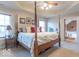 Inviting main bedroom suite with tray ceiling, four-poster bed, and ensuite bathroom, exuding comfort and style at 7823 Beechwood Farms Dr, Avon, IN 46123