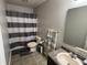 Functional bathroom featuring a shower with a striped curtain, neutral tiling, and essential amenities at 785 Country Gate Dr, New Whiteland, IN 46184