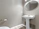 Bathroom featuring pedestal sink and oval mirror at 8212 Nekton Ln, Indianapolis, IN 46236