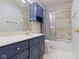 This cozy bathroom includes blue cabinets and shower-tub combination at 8212 Nekton Ln, Indianapolis, IN 46236