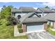 Two-story townhouse showcasing a brick-accented, front-facing garage, and a well-kept lawn at 8212 Nekton Ln, Indianapolis, IN 46236