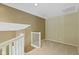 Landing space with neutral carpet and walls, painted white staircase and landing rails at 8212 Nekton Ln, Indianapolis, IN 46236