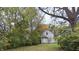 Secluded backyard featuring mature trees, a grassy area, and a charming two-story home at 951 N Tuxedo St, Indianapolis, IN 46201