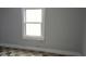 An airy bedroom with a large window, showcasing the original floors awaiting refinishing at 951 N Tuxedo St, Indianapolis, IN 46201
