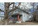 Classic two-story home featuring a welcoming front porch with brick columns and mature trees at 951 N Tuxedo St, Indianapolis, IN 46201