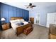 Spacious bedroom with blue paneled accent wall, wooden furniture, and carpeted floors at 9978 Niagara Dr, Fishers, IN 46037
