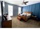 Cozy bedroom featuring blue accent wall, wood furniture, and two windows providing natural light at 9978 Niagara Dr, Fishers, IN 46037