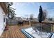 A spacious wooden back deck features an umbrella, table, chairs and grill overlooking the yard at 10154 Holly Berry Cir, Fishers, IN 46038