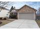 View of the home's brick facade, a large driveway, and an attached two-car garage at 10154 Holly Berry Cir, Fishers, IN 46038
