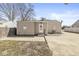Back exterior of home with pink door, cement patio and small yard at 103 S Delawanda Ave, Muncie, IN 47303