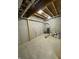 Unfinished basement space showcasing exposed pipes and wooden beams, offering ample potential at 10483 St Anne Dr, Zionsville, IN 46077